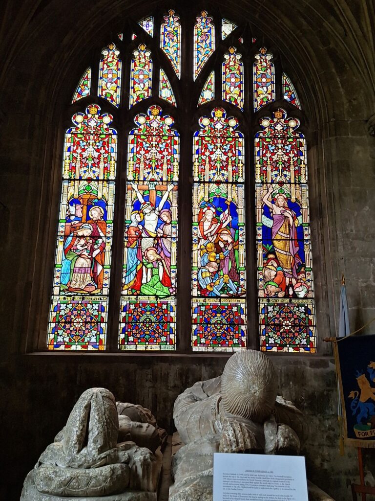 The recumbent tomb of Sir John Kidiock and his wife (15th century) and stained-glass windows (19th century)
