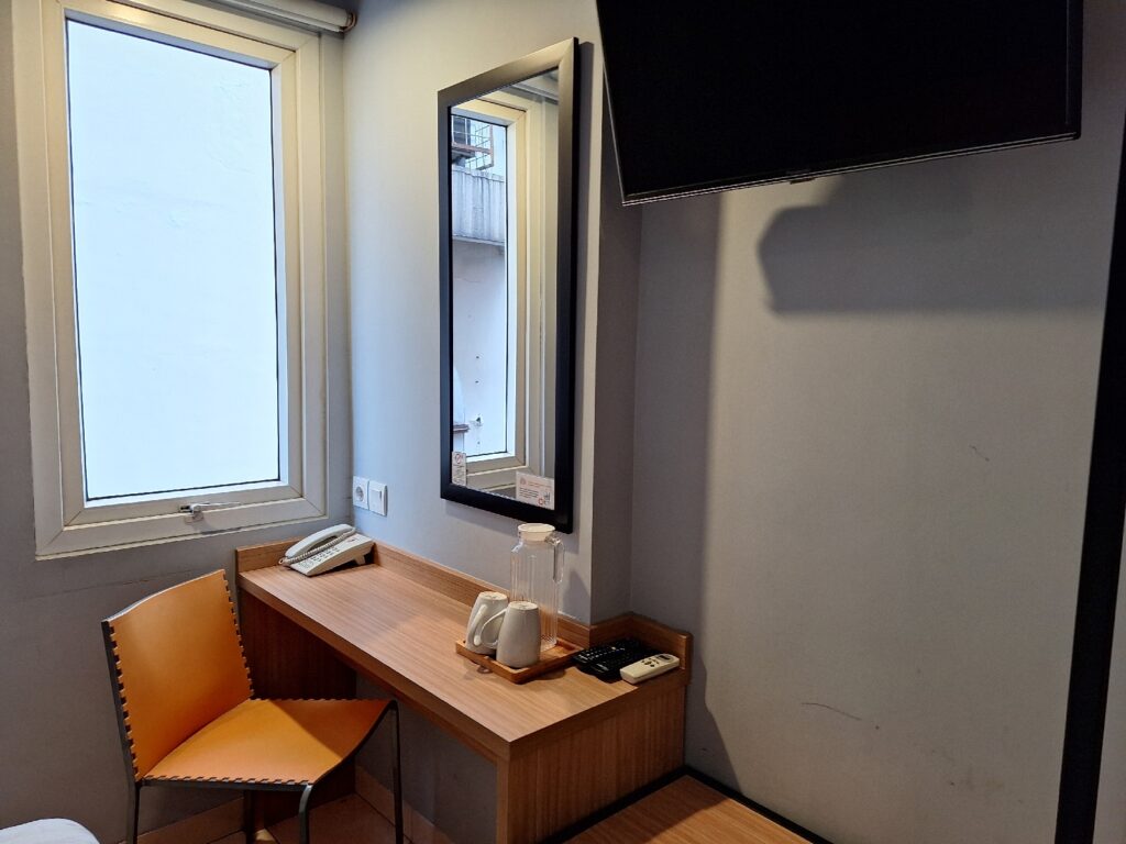 The dest and a chair in our room in Studio One Thamrin Hotel