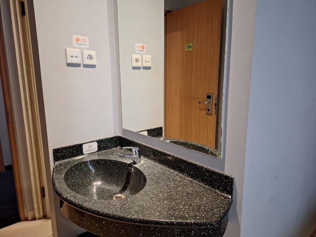 The washbasin is outside of the bathroom in Studio One Thamrin Hotel