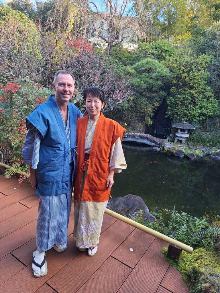 A couple wearing Japanese Yukata and standing in front of the Japanese garden in a traditional Onsen Ryokan